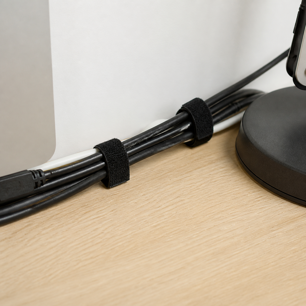 Velcro negro sujetando cables debajo de un escritorio