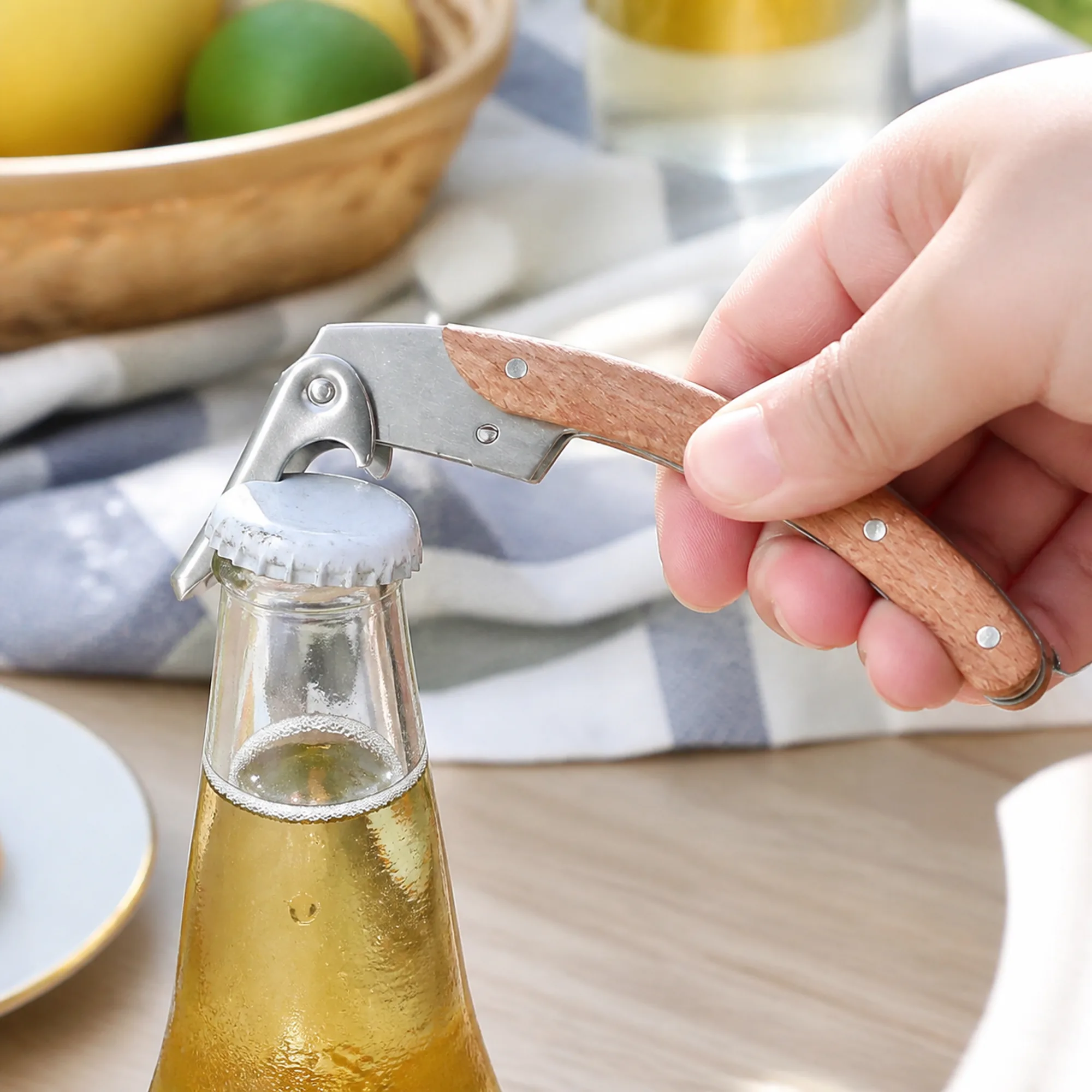 Abrebotellas con mango de madera retirando una tapa corona