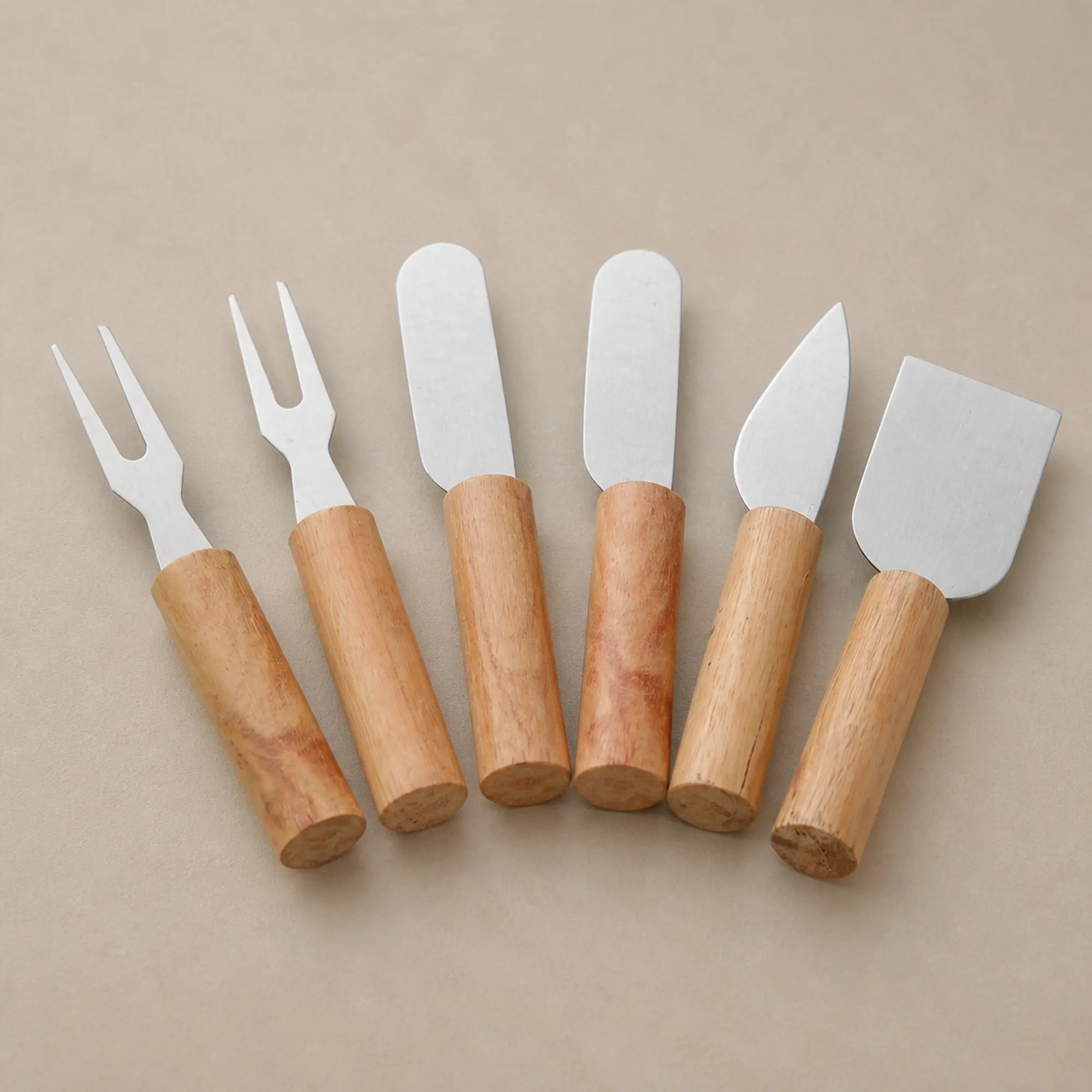 Detalle de seis utensilios con dos tenedores y cuatro esparcidores de mango de madera